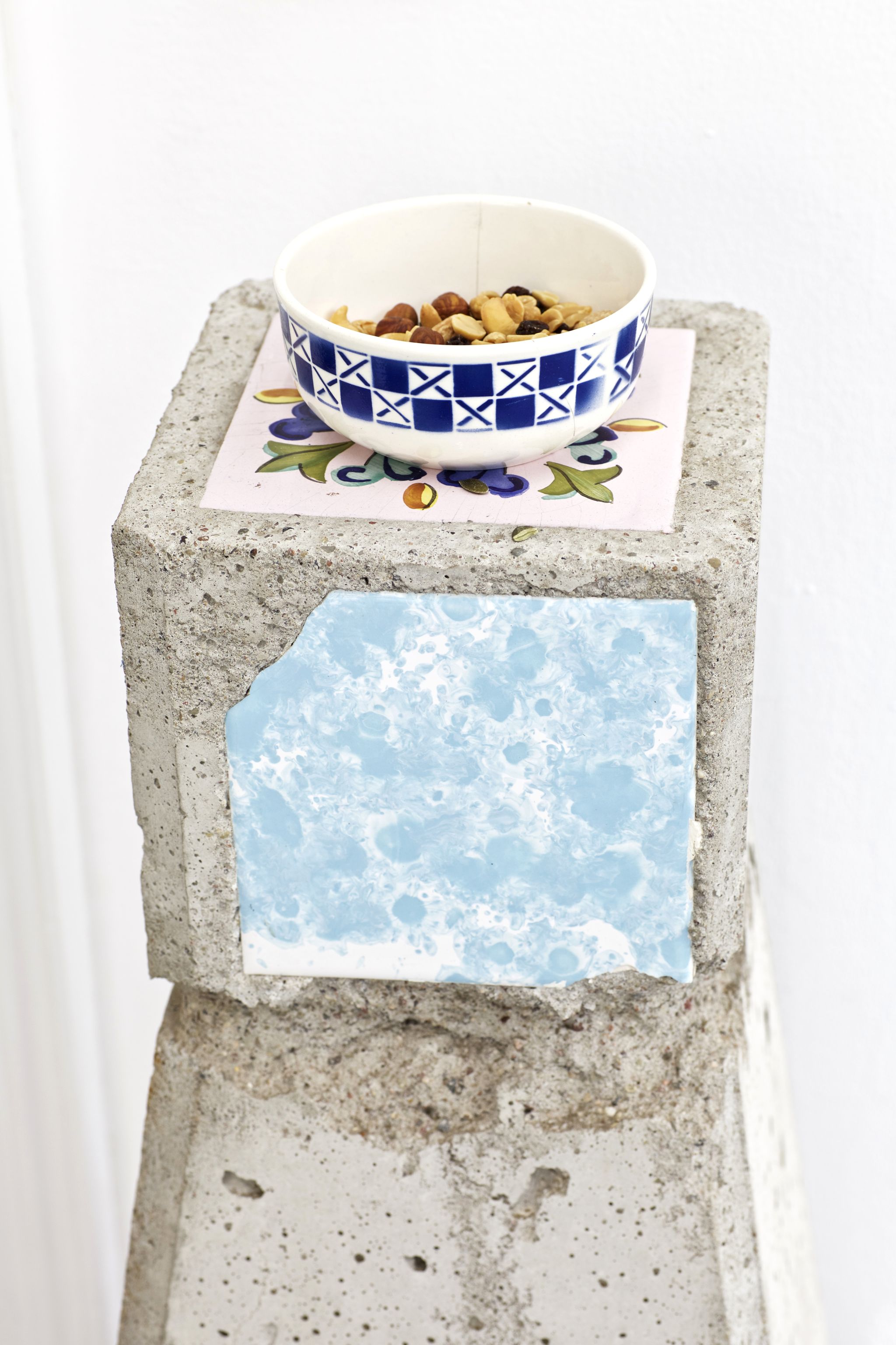 Manfred Pernice & Martin Städeli, Abbruch (d. Bez.) (detail), 2015, Cement, tiles, one bowl, snack mix, 1 tomato carton, 1 bottle holder, 2 jigsaw puzzle borders, 2 paper mache objects, 1 synthetic butterfly, 1 copy (Das Holz ist teuer und . . .) (H. Daumier), Site specific