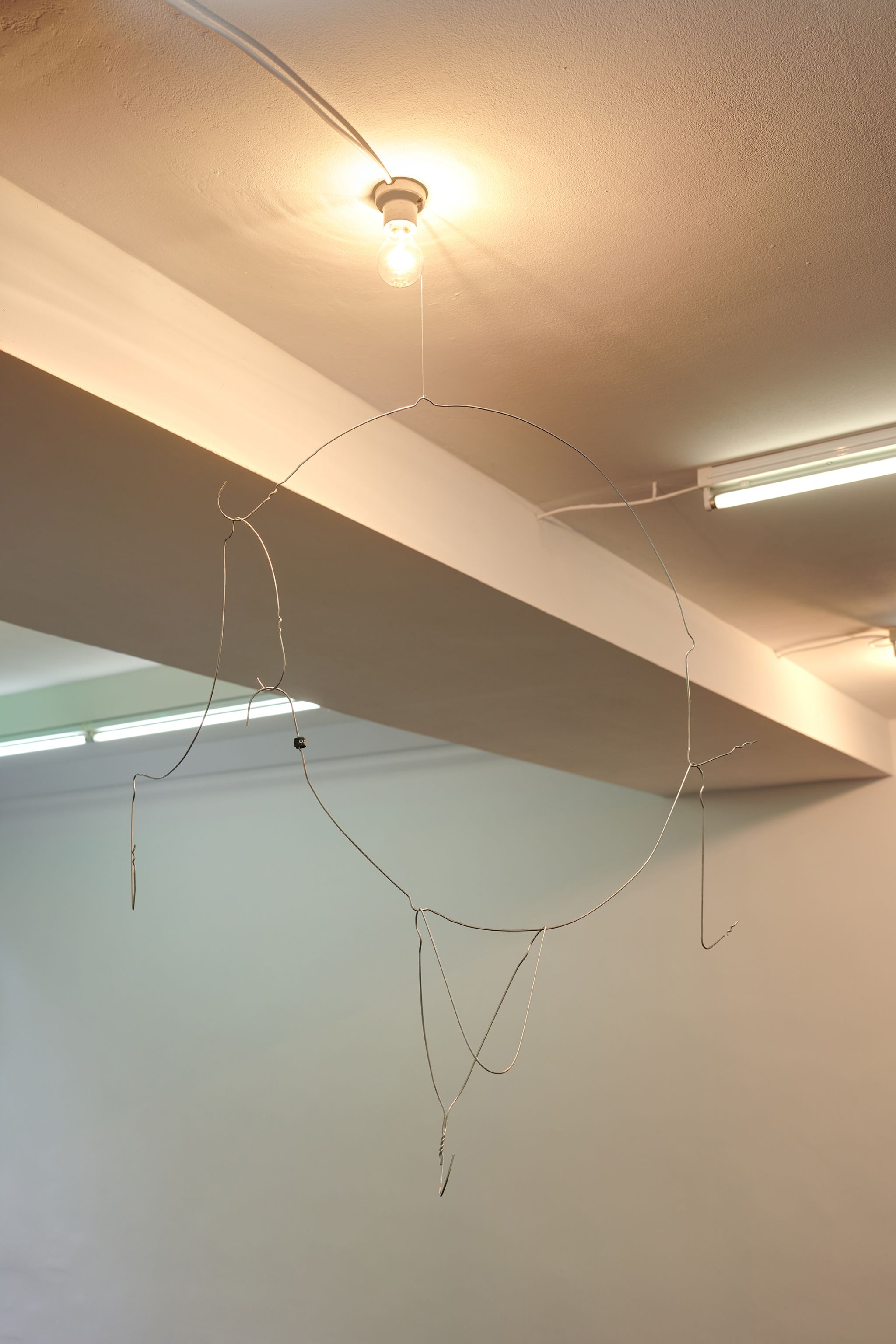 Davide Stucchi, Milan (Mobile 4) Corridor, 2020, Ceramic lamp holder, light bulb, aluminum clothes hangers, size marker, 118 ⁠× ⁠70 ⁠× ⁠45 ⁠⁠cm